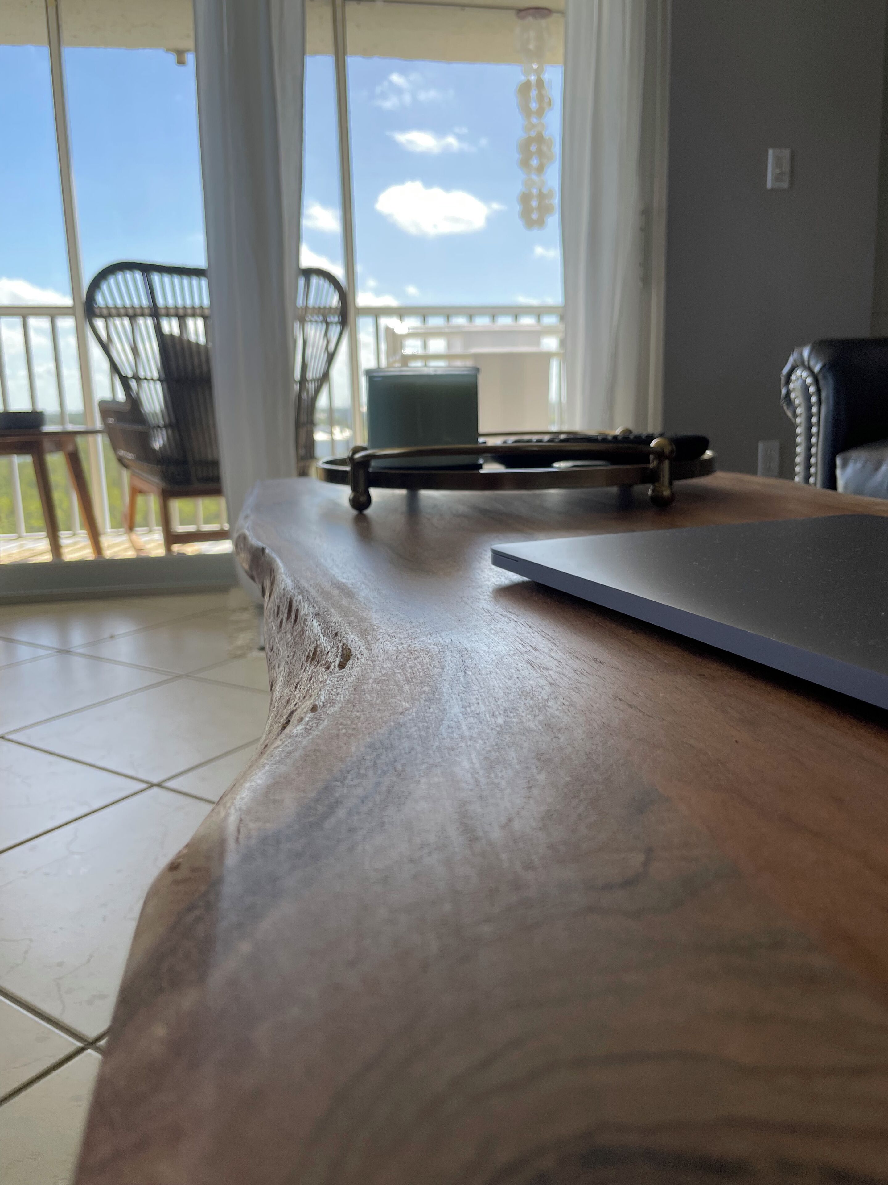 A wooden table with a laptop and a small table lamp.