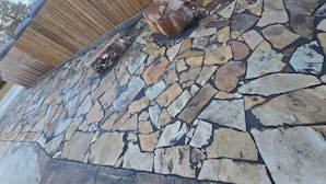 Eine Steinmauer mit einem Holzzaun und einer Steinfläche.