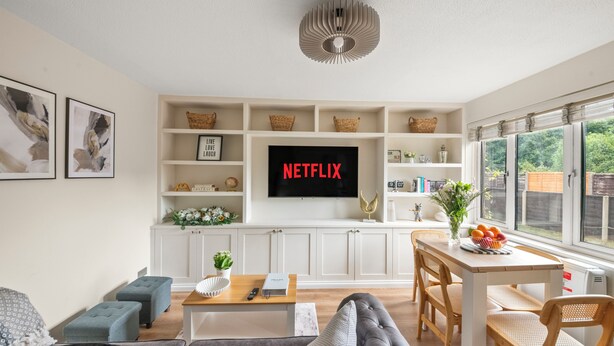 Un soggiorno moderno con una televisione a schermo piatto, un tavolo da pranzo e una zona salotto accogliente.