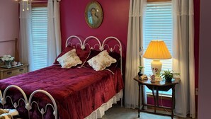 Une chambre à coucher avec un lit, une table de chevet, une lampe et un ventilateur de plafond.