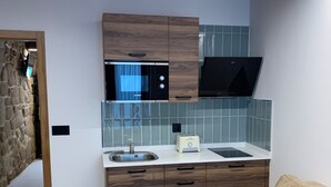 A compact kitchen with wooden cabinets, a built-in microwave, and a toaster. - MAR DE MUROS (Muros)