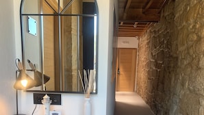 A wooden desk with a mirror, a lamp, and a vase with sticks. - MAR DE MUROS (Muros)