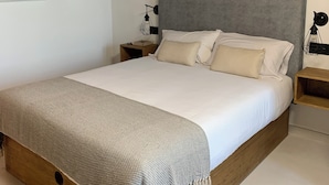 A bedroom with a large bed, wooden headboard, and a nightstand with a lamp. - MAR DE MUROS (Muros)