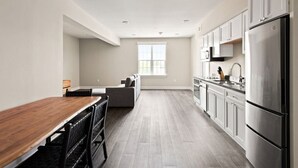 Una cocina moderna con comedor, un amplio ventanal y horno empotrado.