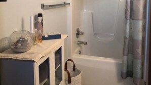 Ein Badezimmer mit Badewanne, Duschvorhang und Handtuchhalter.