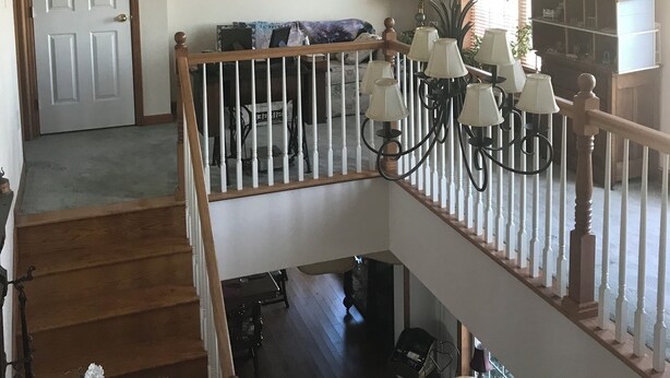 Ein großzügiger Wohnbereich mit einer Holztreppe, einer Kronleuchter und Blick auf die untere Etage.