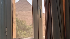 Une pièce avec une fenêtre donnant sur un paysage montagneux.