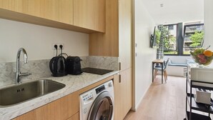 A modern kitchen with a built-in washing machine, a sink, and a coffee maker. - TBS 167 - Refined and bright studio (Paris)