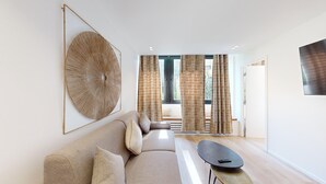 A modern living room with a sofa, a coffee table, and a large abstract artwork.