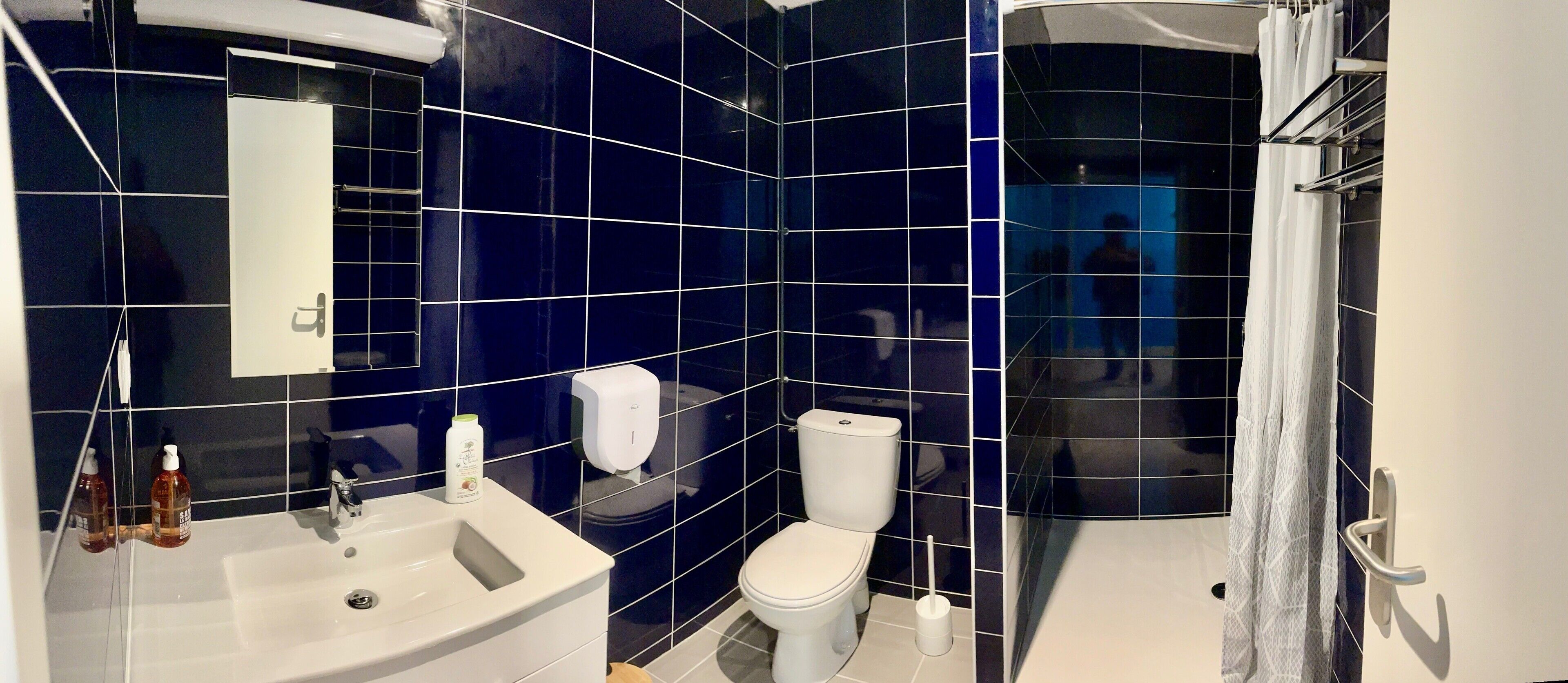 Un baño con un lavamanos blanco, un inodoro y una zona de ducha.