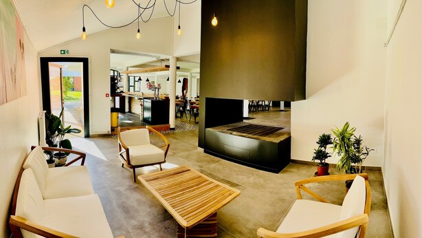 A modern interior with a reception desk, seating area, and a large wall with a built-in bench.
