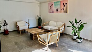A modern living room with a sofa set, a coffee table, and potted plants.