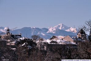 Un pueblo cubierto de nieve con edificios históricos y una montaña al fondo.