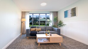A living room with a grey sofa, a wooden coffee table, and a floor lamp.