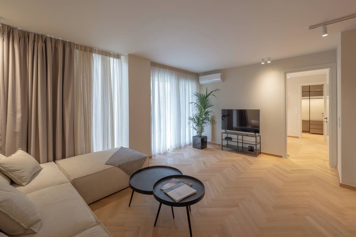 A modern living room with a sofa, a coffee table, and a TV.
