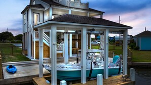 Una casa con un muelle techado y un bote.