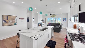 A modern kitchen with white cabinetry, a central island, and a gas stove.