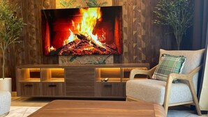 Un salon moderne doté d’un grand téléviseur, de meubles en bois et d’un mur décoratif.