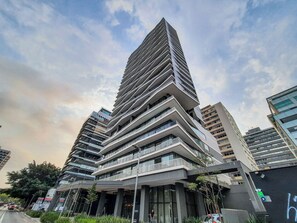 A modern high-rise building with multiple balconies and large windows. - JFL prédio completo com café da manha (São Paulo)