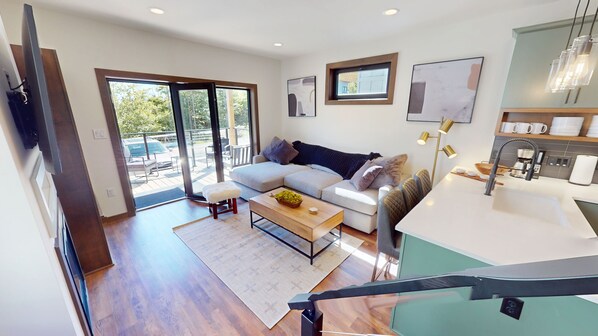 Una sala de estar moderna con sofá, mesa de centro y vistas al exterior.