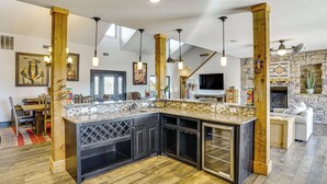 A spacious kitchen with a large island, wooden beams, and pendant lighting. - Hot Tub + Fire Pit: Possum Kingdom Lake Retreat! (Strawn)