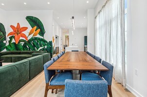 Una sala de reuniones moderna con una mesa de madera, sillas tapizadas en azul y un sofá verde.