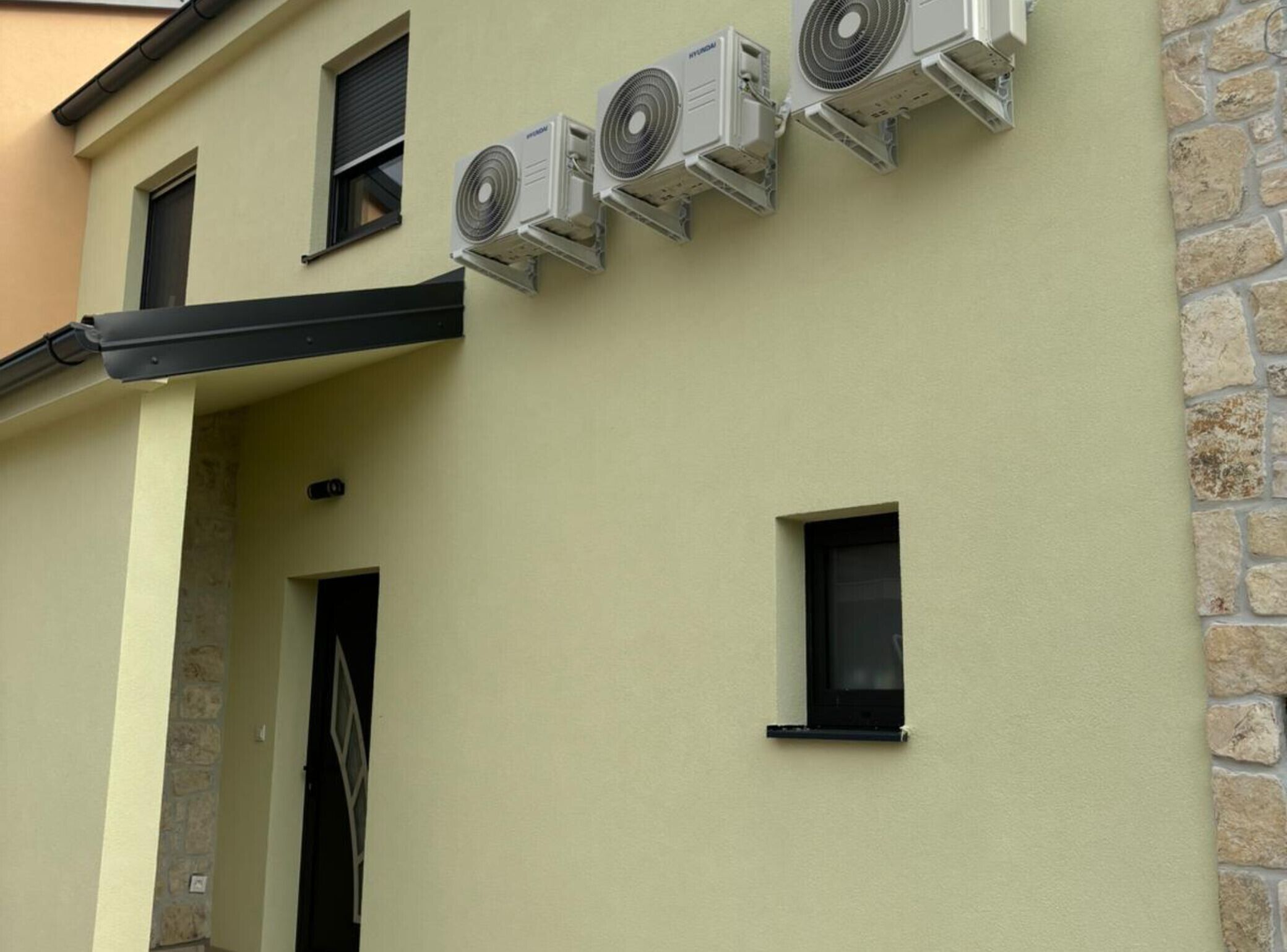Un edificio con varias unidades de aire acondicionado instaladas en la pared exterior.