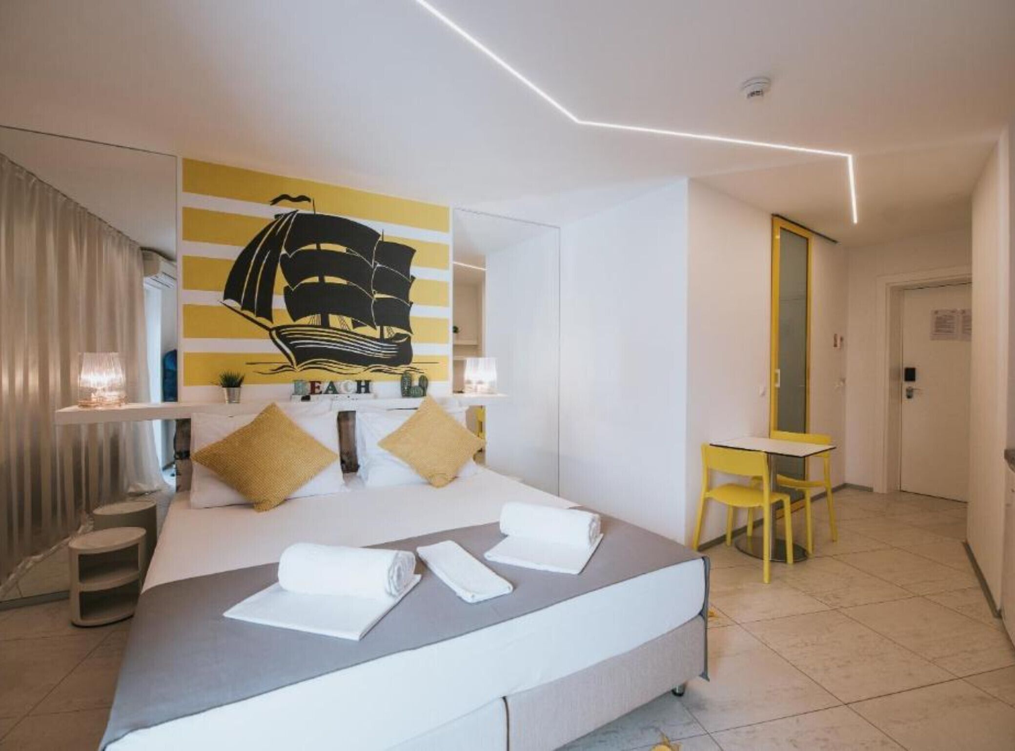A modern hotel room with a bed, a desk, and a chair.