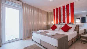 Une chambre d’hôtel moderne, dotée d’un grand lit, d’une table de chevet, d’un miroir et offrant une vue sur l’extérieur.