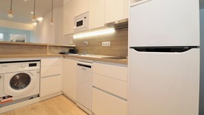 Una cocina moderna equipada con lavadora, lavavajillas, microondas y refrigerador LG.