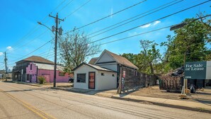 Un petit bâtiment sur lequel on peut voir une pancarte indiquant « À vendre ou à louer », une autre pancarte indiquant « Paiement ici » et une pancarte CBRE.