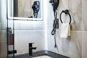 Klassieke eenpersoonskamer | Badkamer | Een douche, gratis toiletartikelen, een haardroger, handdoeken