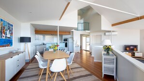 A modern apartment with a dining area, kitchen, and living space.