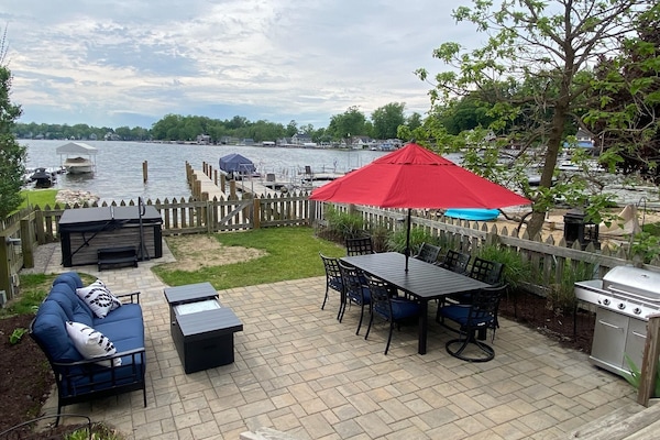 Cozy outdoor living with large dining table, grill, firepit table, and hot tub.