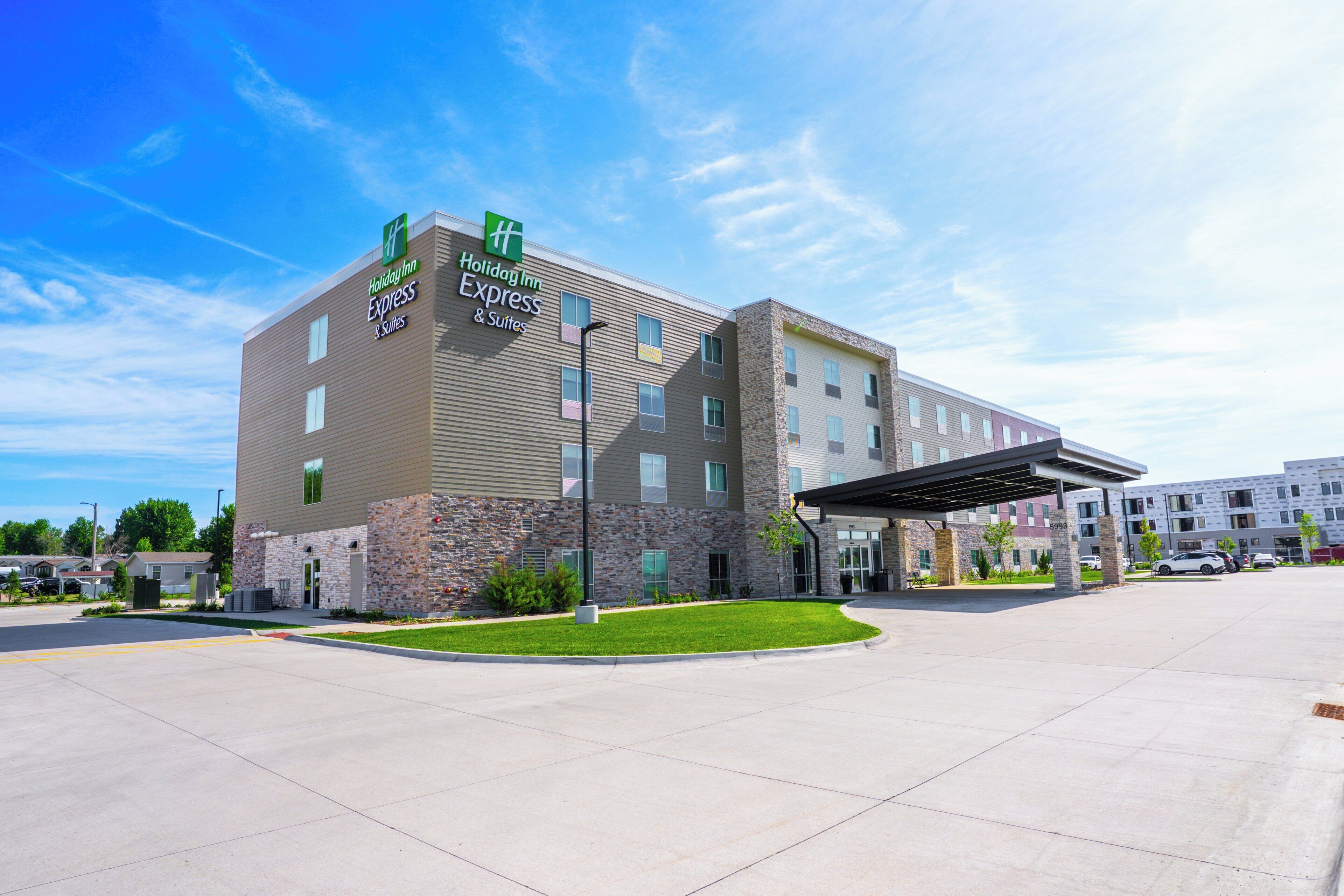 Een Holiday Inn Express gebouw met een stenen gevel, veel ramen en een overdekte ingang.