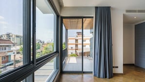 A modern apartment with large windows, a balcony, and a view of the cityscape. - The Designer 49 Villa (Bangkok)