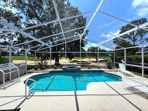 A covered swimming pool with a clear view of the surrounding landscape, including a golf course and trees. - 8th Fairway, Private Pool Villa, Southern Dunes (Haines City)