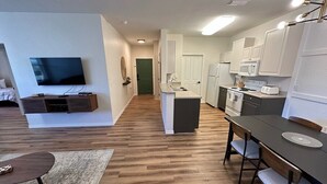 Un appartement moderne comprenant une cuisine, un coin repas et un salon.