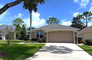 A residential house with a garage, a driveway, and a well-maintained lawn.
