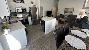 A modern kitchen with white cabinets, stainless steel appliances, and a central island. - South Facing Pool Villa, Golf Course Views, Southern Dunes (Haines City)