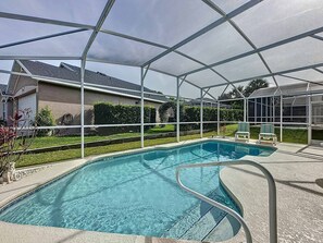 A clear blue pool with a metal safety railing, surrounded by a covered patio area. - 2200mac - Southern Dunes Villa (Haines City)