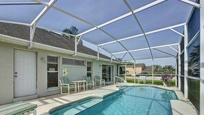 Una piscina scoperta coperta, con lettini e una porta che dà su un edificio.