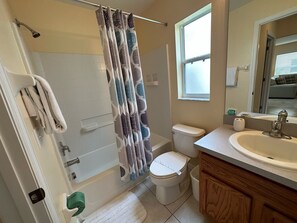 A bathroom with a shower, toilet, sink, and a window. - Stunning Villa With Golf Course Views (Haines City)