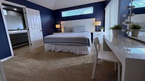 A bedroom with a bed, bedside table, lamp, mirror, and potted plants. - South Facing Villa - Modern Finishes (Haines City)