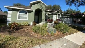A residential house with a front yard, a driveway, and a garage. - Golf Course Views, Large Pool Deck Villa in Southern Dunes (Haines City)