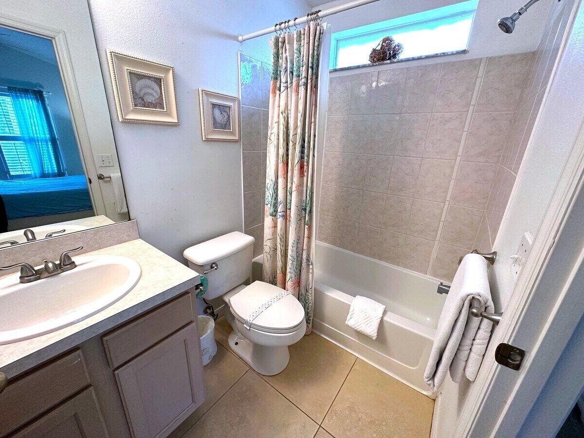 A bathroom with a toilet, sink, and bathtub.