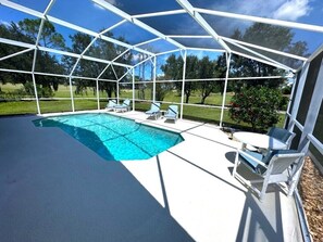 A covered outdoor swimming pool with lounge chairs and a pergola structure. - Updated, Private Villa, Southern Dunes, Extended Pool Deck (Haines City)