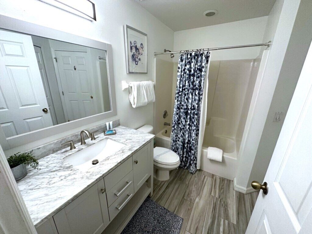 A bathroom with a sink, toilet, and shower.