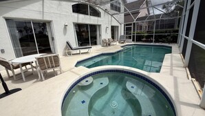 A swimming pool with a hot tub, lounge chairs, and a covered patio area. - 8th Fairway Pool Villa, Southern Dunes (Haines City)