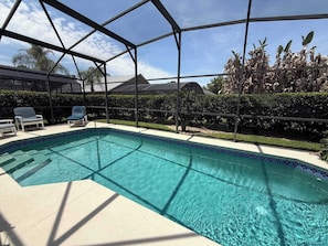 A swimming pool with a clear blue water, surrounded by a metal fence, and a few lounge chairs. - Private Pool Villa, Many Updates! Southern Dunes (Haines City)
